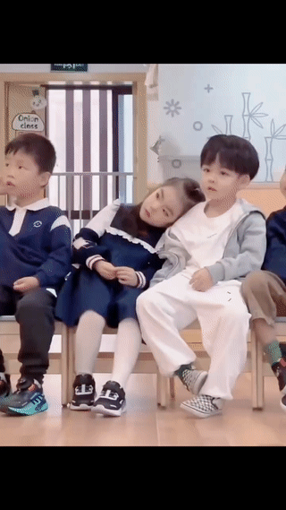 幼儿园里拍到的温馨一幕。
小男孩轻轻抚摸着旁边小女孩的辫子。
小女孩则顺势歪下头