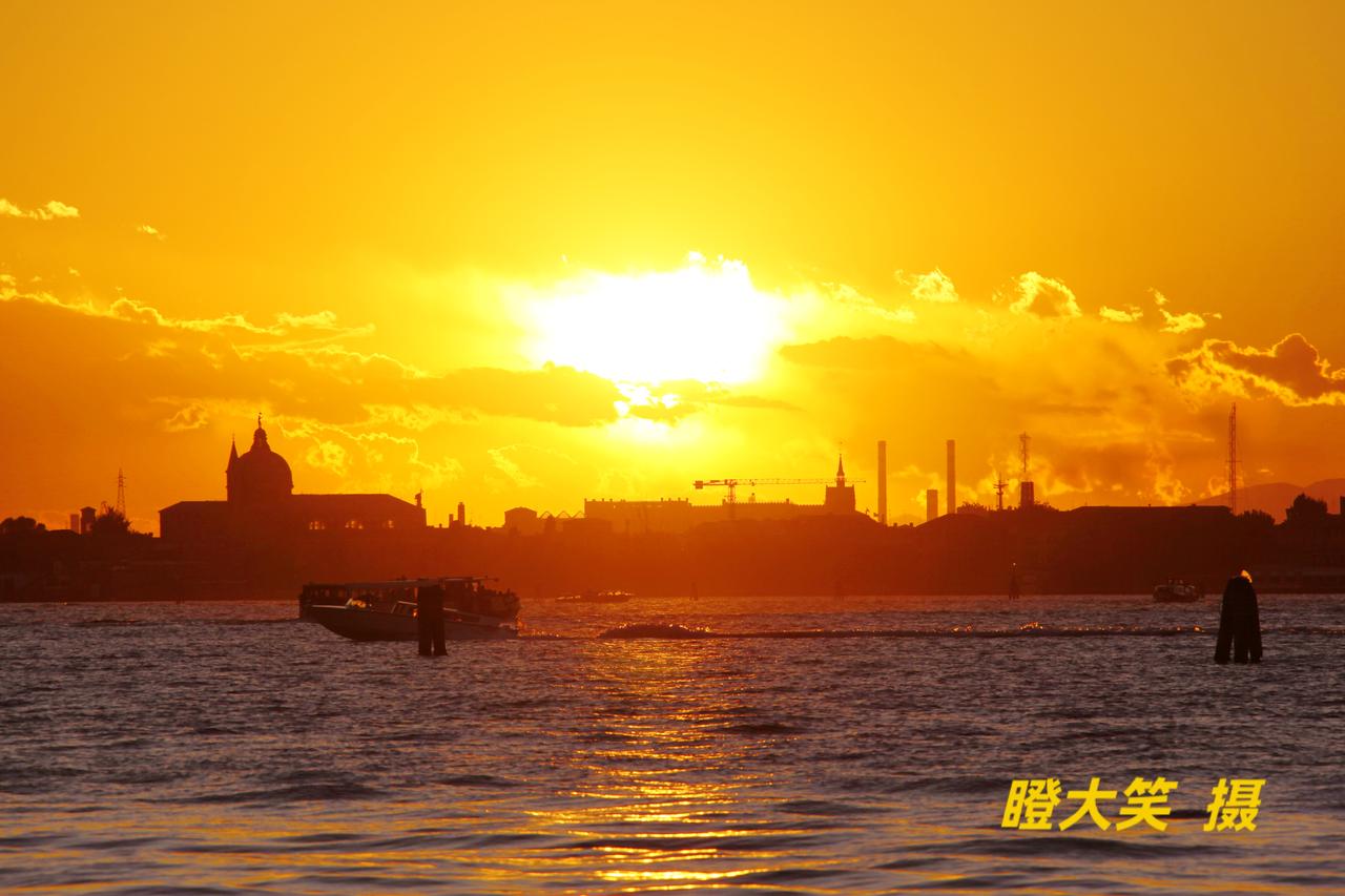 分享一张你手机里最近拍的风景照夕阳西下，站在水城威尼斯岸边，隔海眺望对岸的利多岛