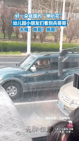 “嘴角压不住了！”河南，一幼儿园萌娃在等红灯时，不料，瞅见了旁边军车上同样等红绿