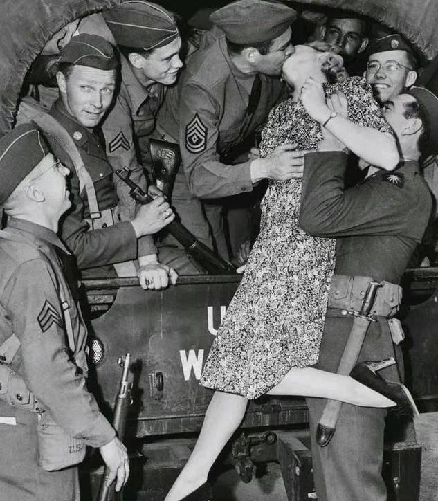 1940年代，一名美国妇女被一名美国大兵抱起，和卡车上的另一位美军士兵亲吻。
 