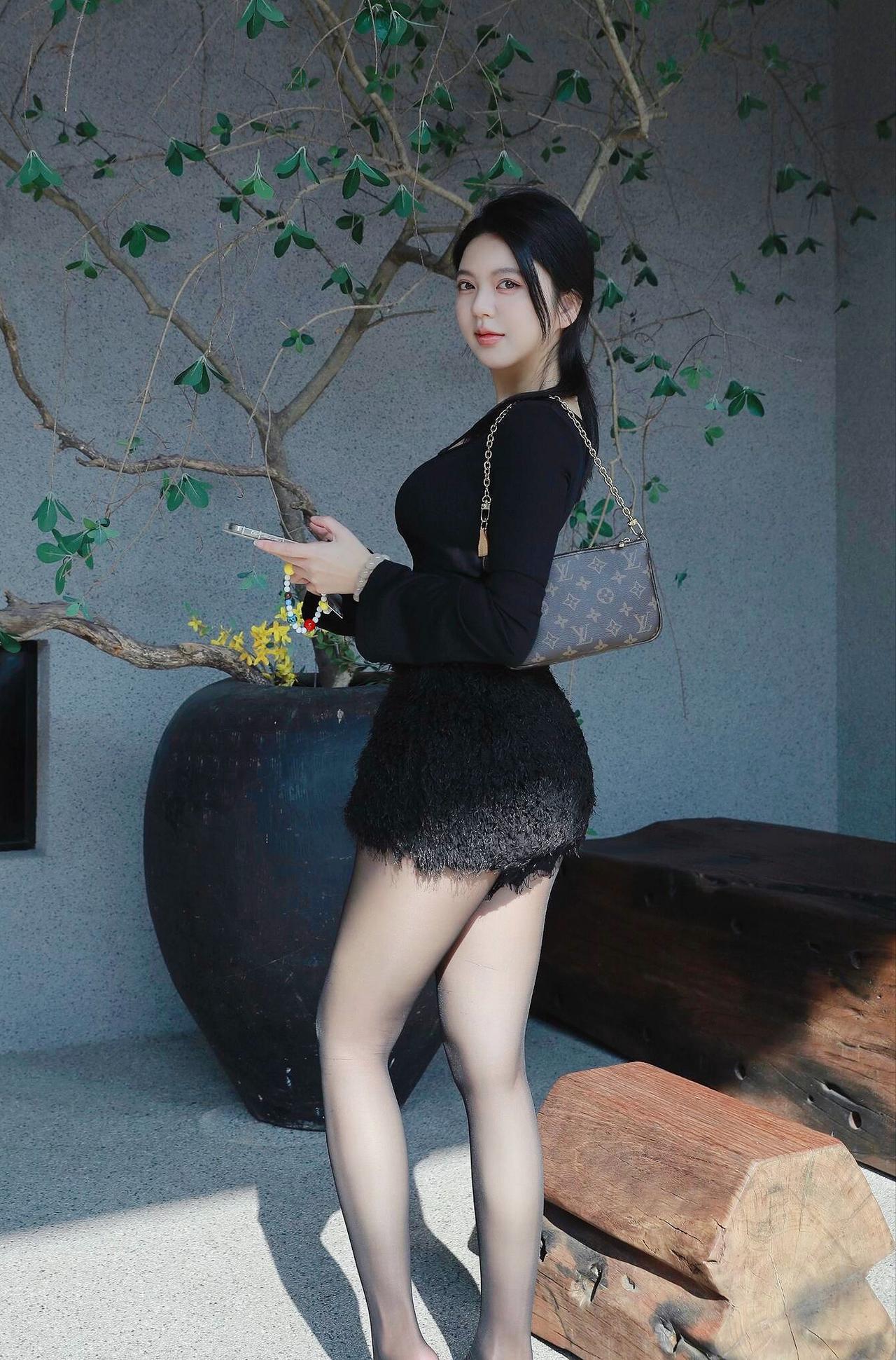 《黑衣照》
 原创诗词 原创看图片配诗 
素墙青树映流光，黑裙轻覆软茸长。
腕底