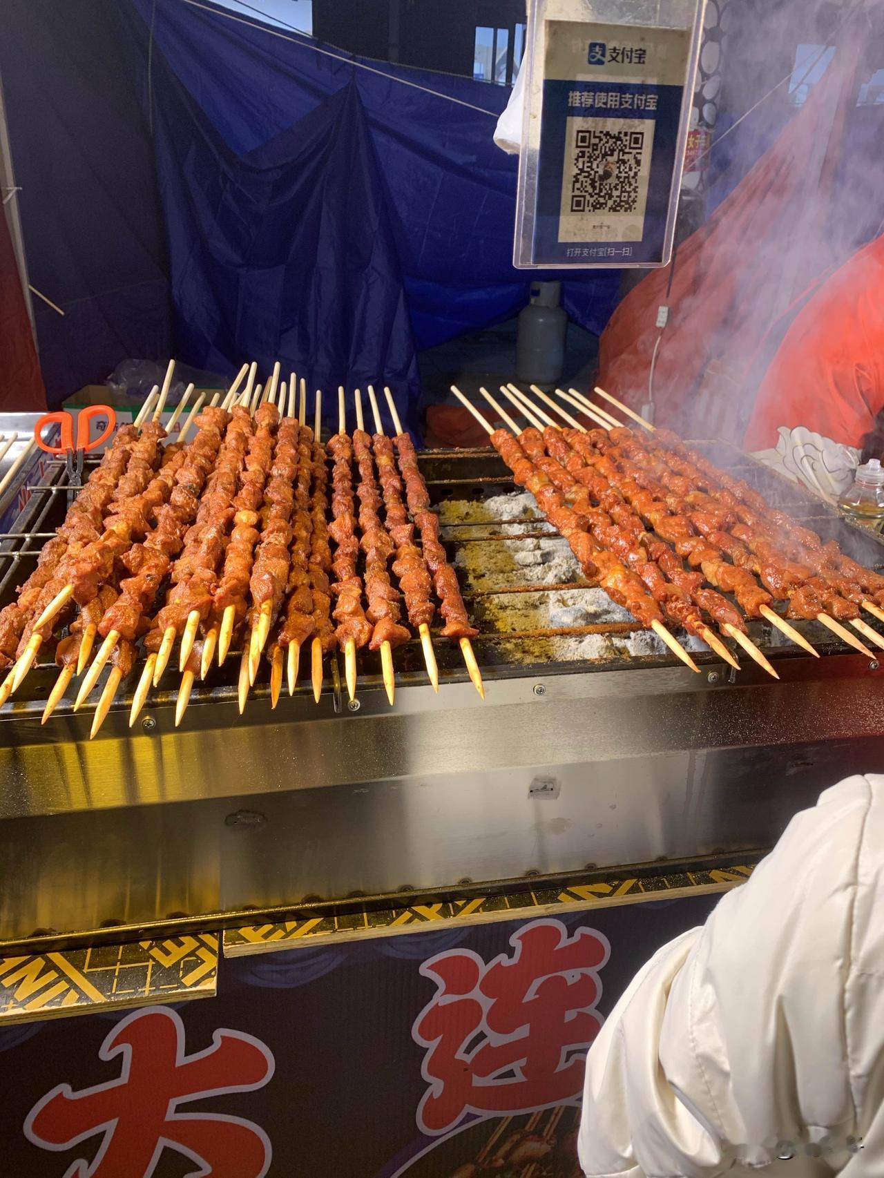 带娃去农村赶集，一米长的“牛肉串”只卖15元？一群人在摊前围观。骑车快到集市上就