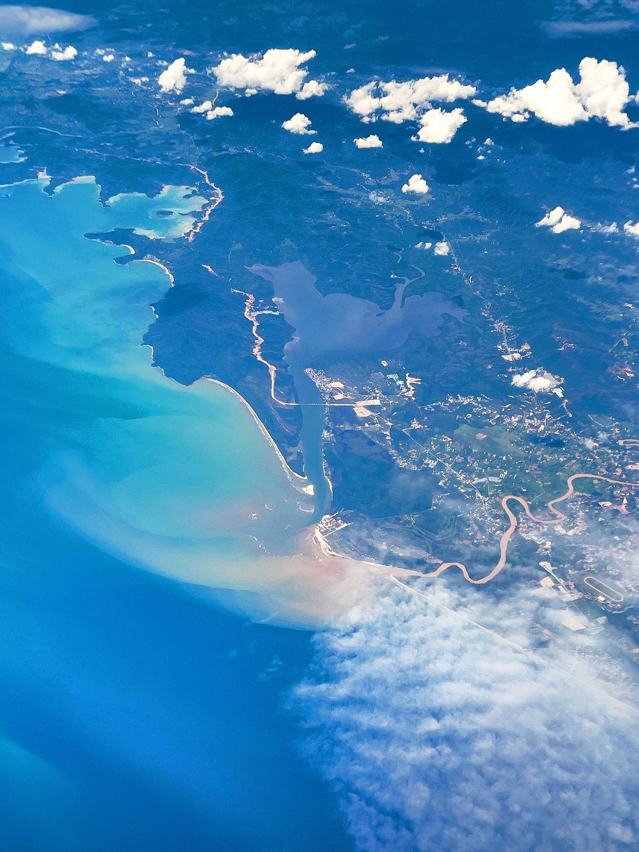 【云端赴山海】万米高空之上，机翼掠过绵软云团。
深蓝大海衔着蜿蜒岸线，山河与海湾