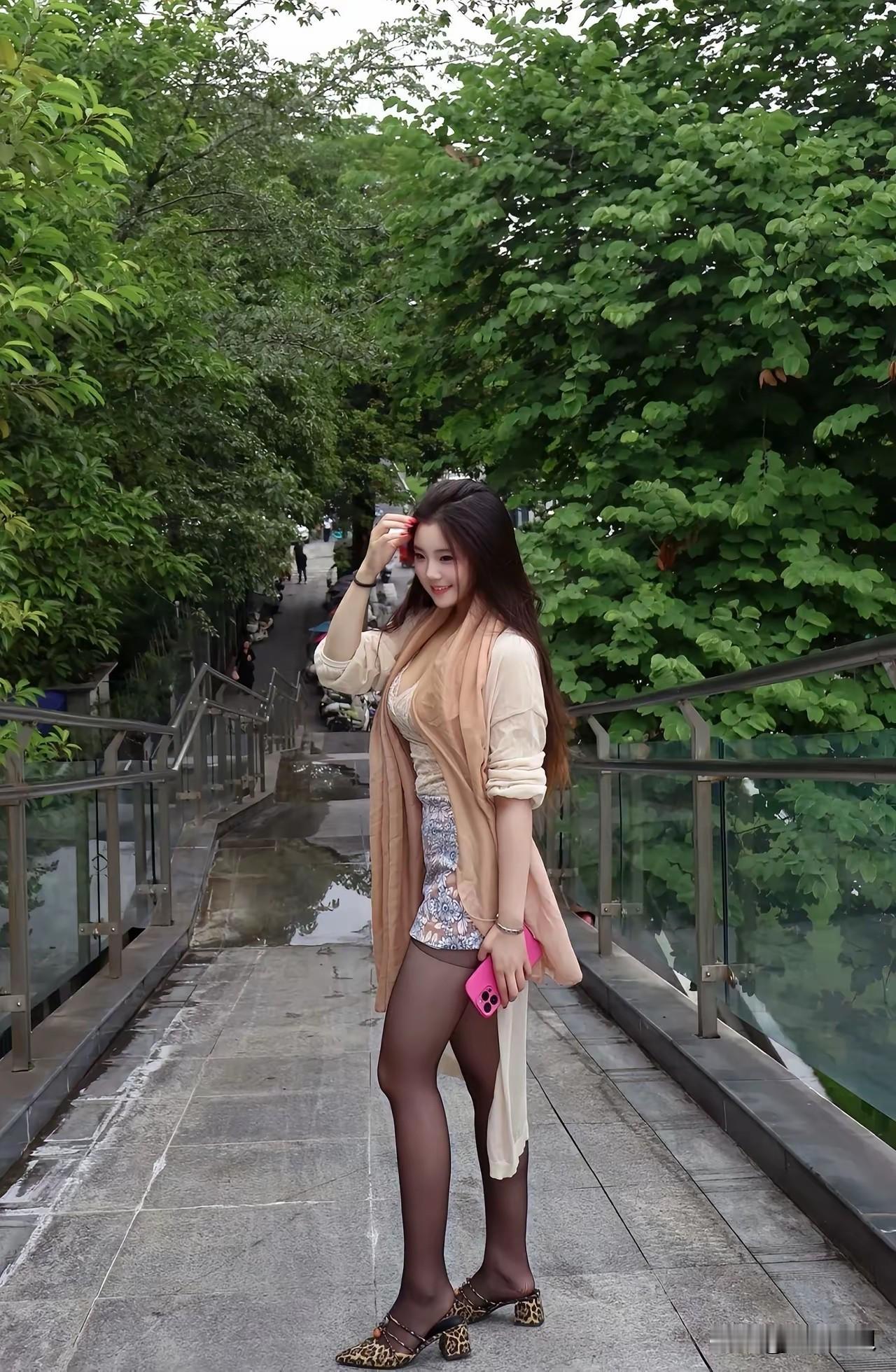 一个美女在桥上摆姿势拍照。