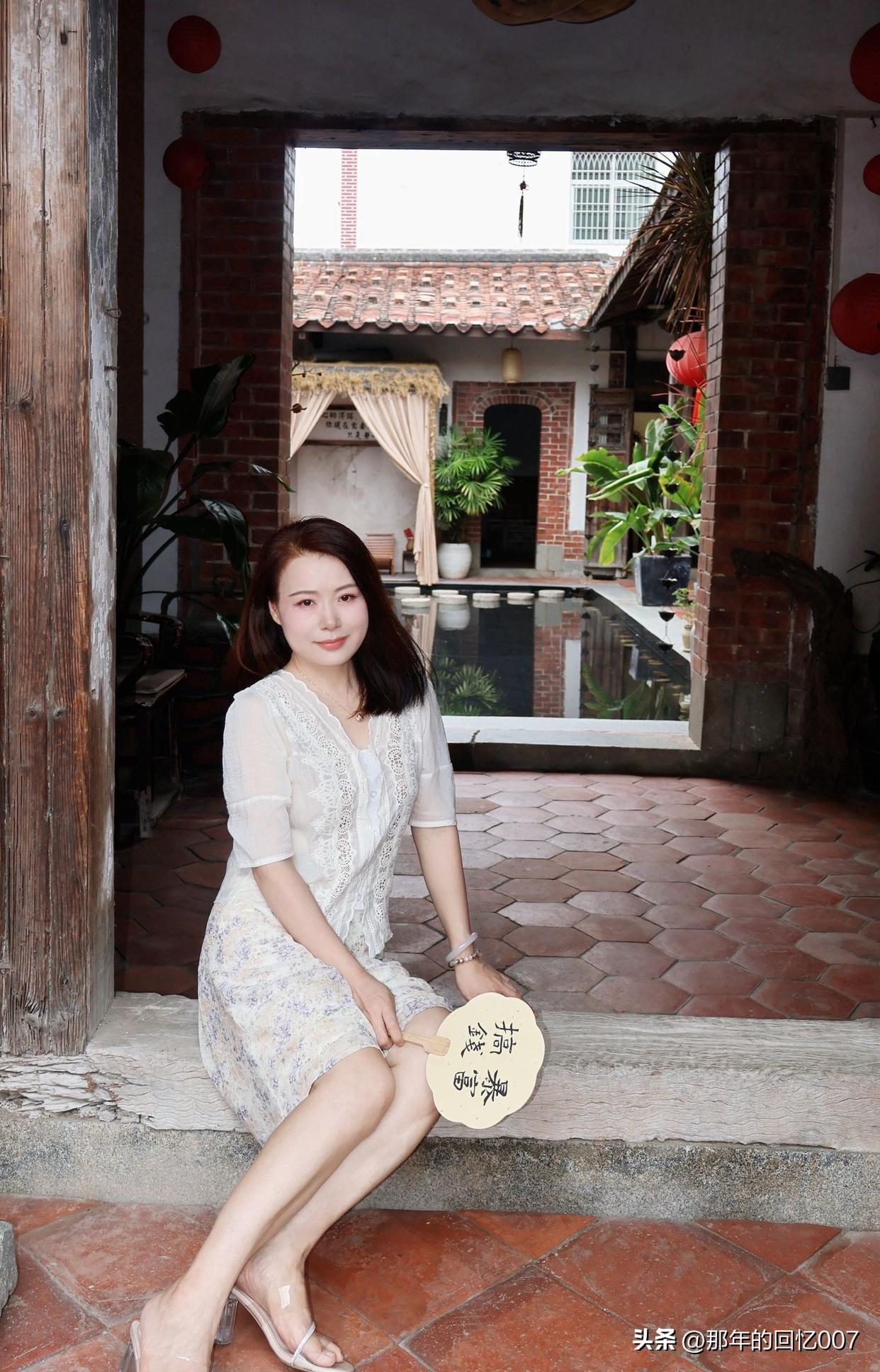 50岁左右的女性早秋裙子怎么穿? 红砖墙前，白裙少女倚靠，静谧时光