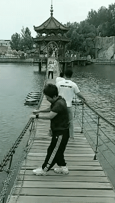 这个大妈，她是在演戏，还是在直播？

这明明是某景区景点儿里水上的一个软吊桥，供