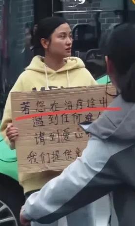 四川成都，华西医院门口有一个女孩子胸前举着一块牌子，写着提供免费住宿吃饭，很多人