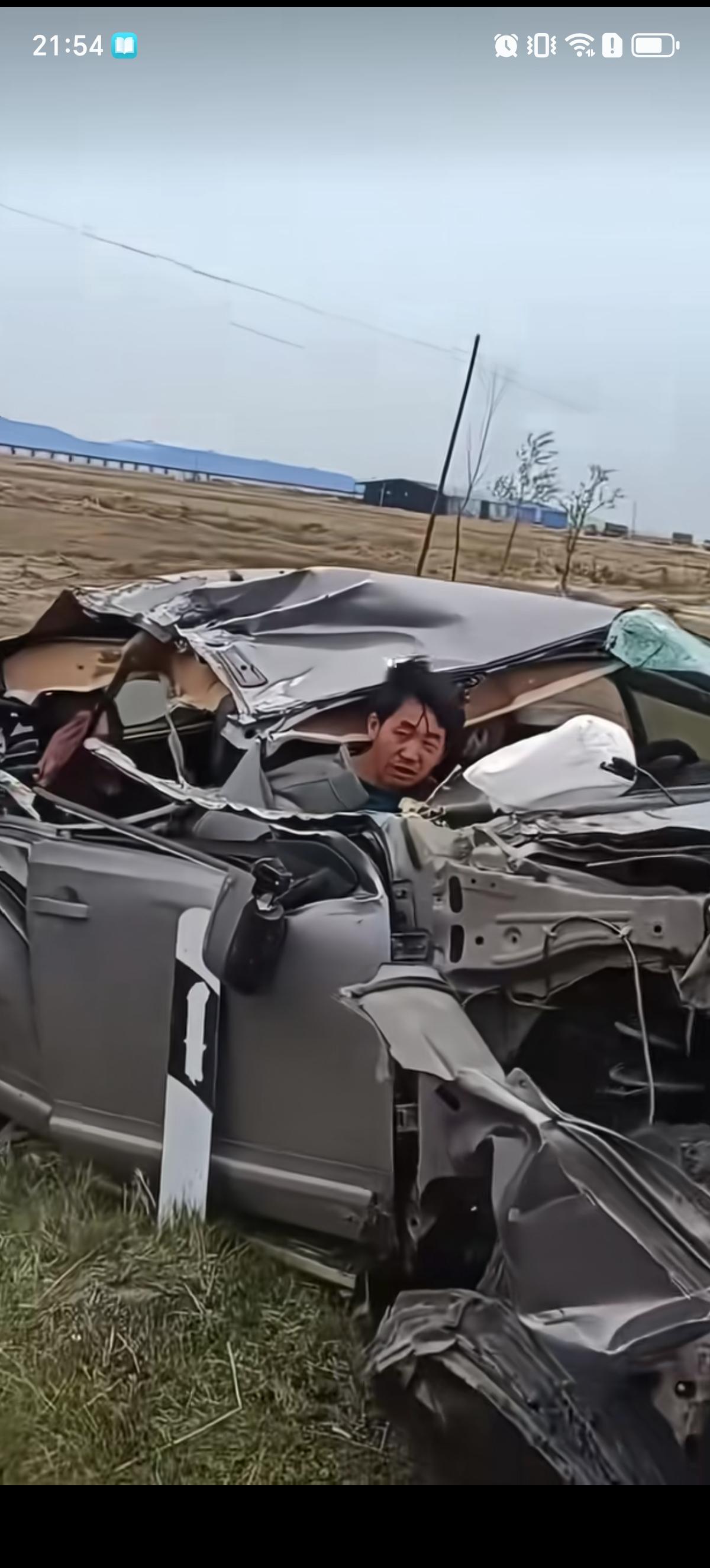 男子开着小轿车直接撞上了一辆重型半挂大货车，把车头都撞开壳了。男子和自己车后座的