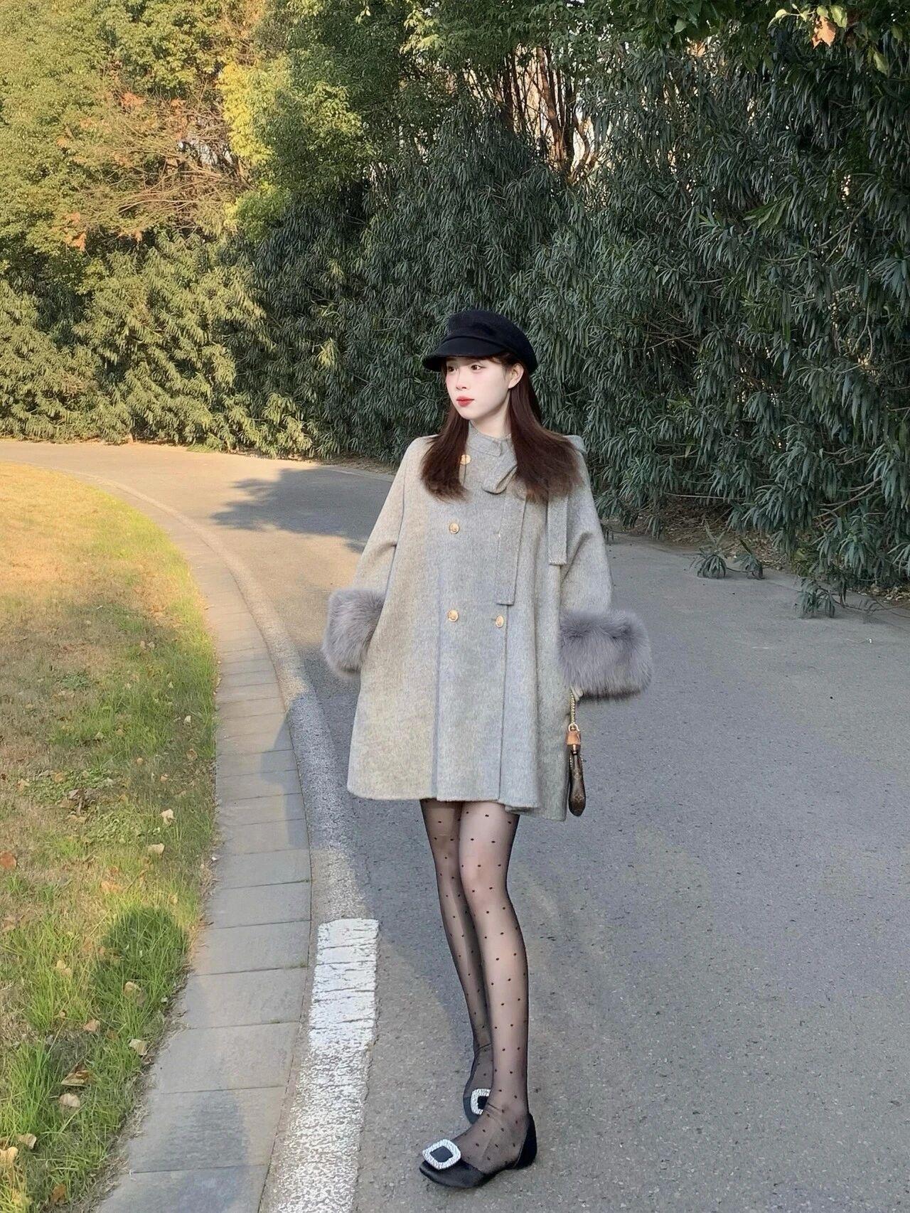 大衣和波点黑丝的搭配真的惊艳到了！
这套浅灰色中长外套搭配波点袜，再加上带方扣的