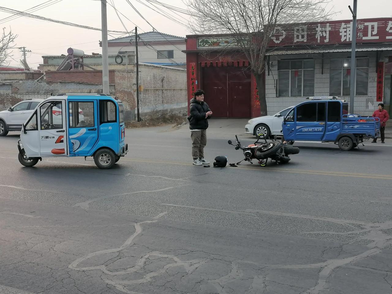 就在交通部门的标语旁“超速行驶就是抢占边不远处，有电动车和摩托车不小心相撞了，虽