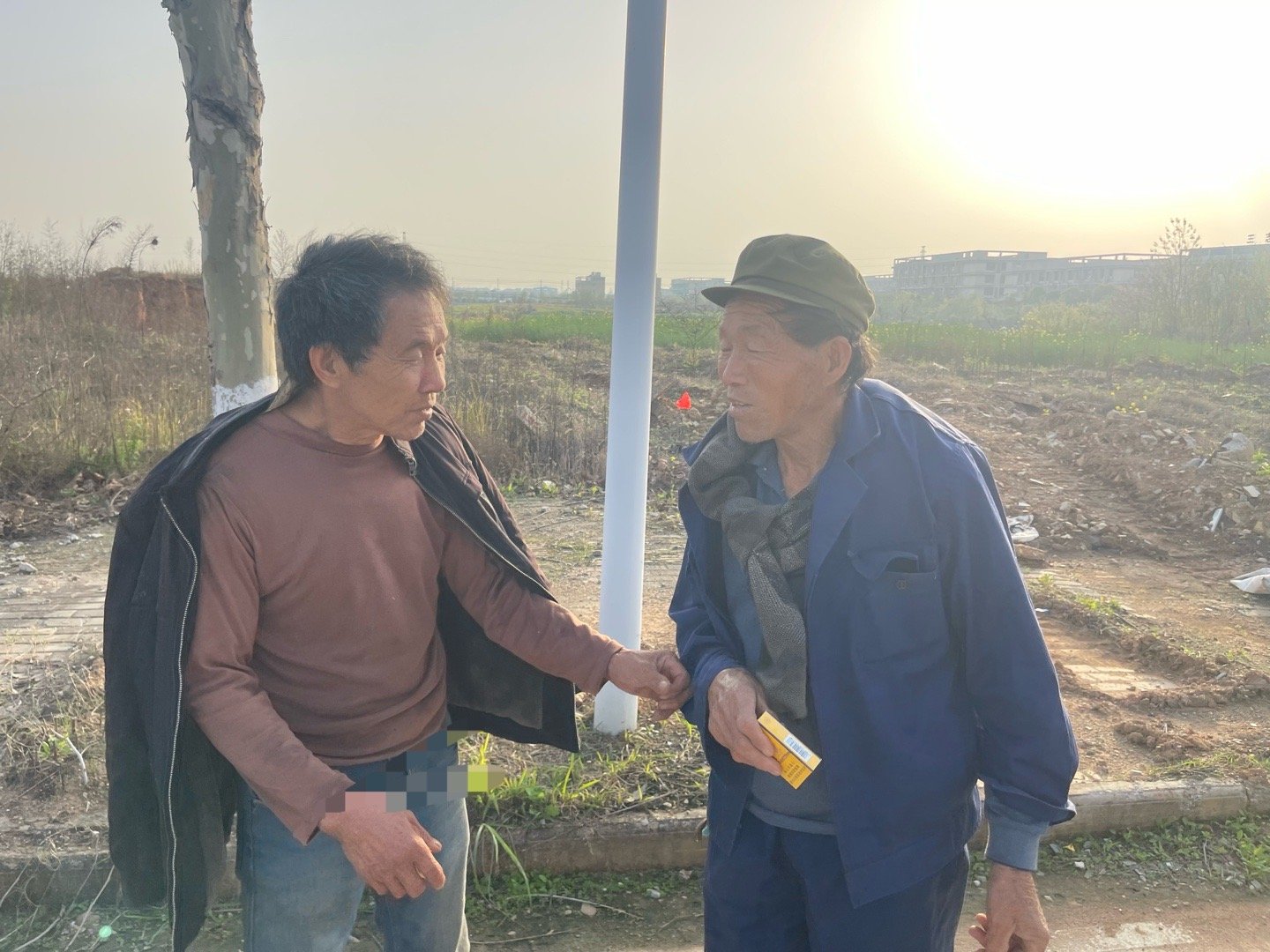 老爸和他的亲二哥，给他们的爸爸妈妈竖好石碑。老爸给他二哥一盒烟，拉拉扯扯，下次再