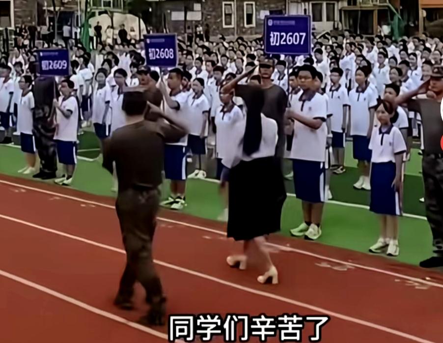 画面是某校开学典礼，女校长手持话筒正在举行阅生仪式，就差安排个车了，典型的不论不