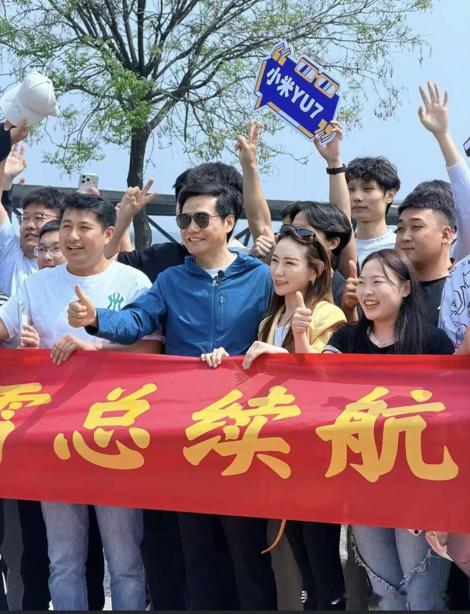 今天在临沭服务区蹲守雷总给车充电，车友们和雷总一起合照，雷总旁边的这个女子踮着脚