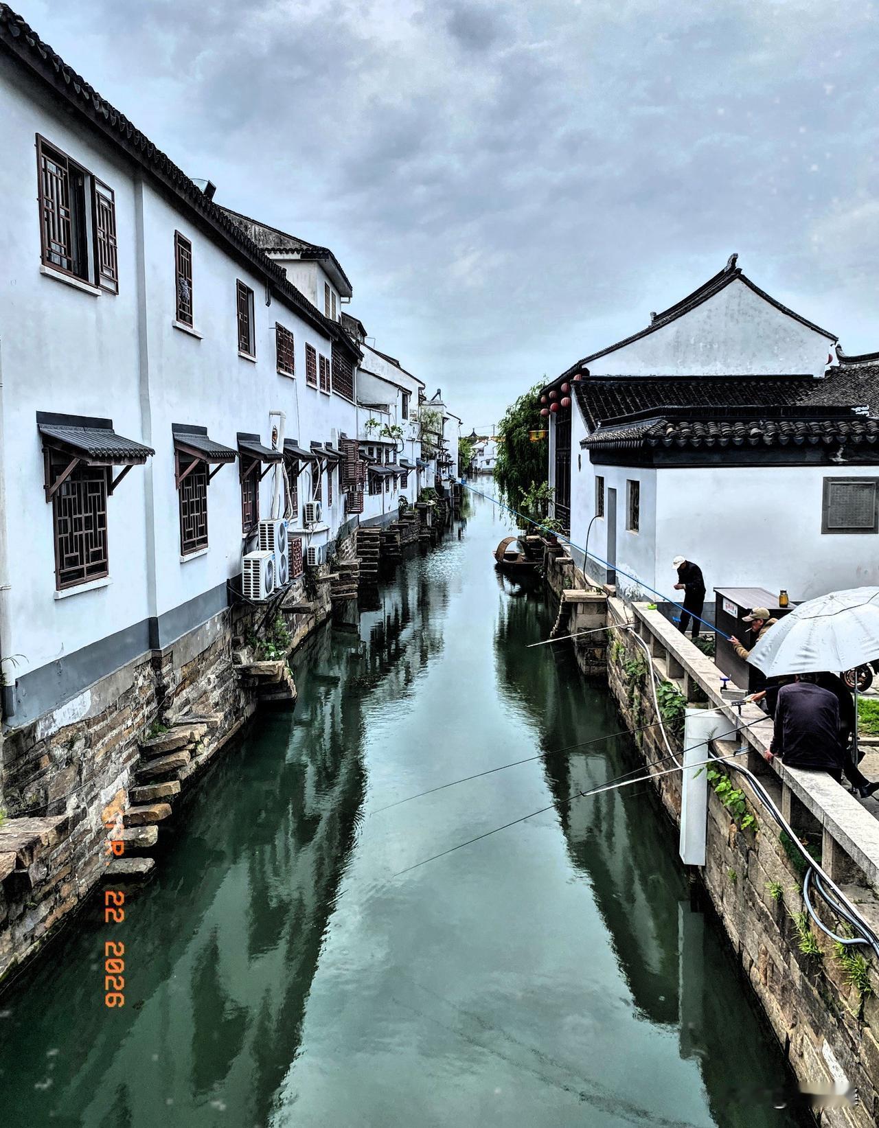 《闲暇苏州泰伯庙钓鱼人的包容关联度》
好多人在苏州泰伯庙前的城河里钓鱼，他们身后