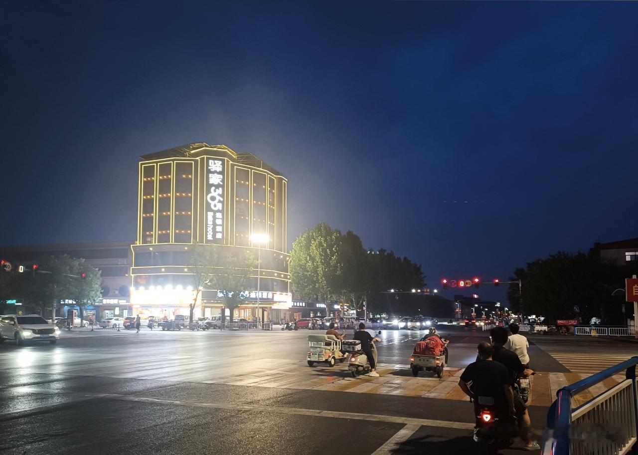 傍晚时分的沙河市南道口（宋璟路与太行大街交汇处）矗立着驿家365连锁酒店与好想来