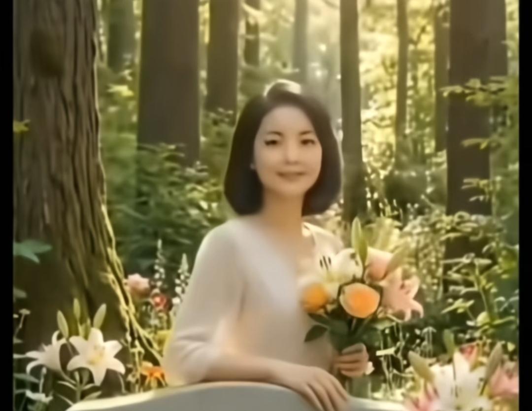她在森林里拿着花微笑。她到底是台湾的，还是香港的？还有人记得她吗？她视角的美景