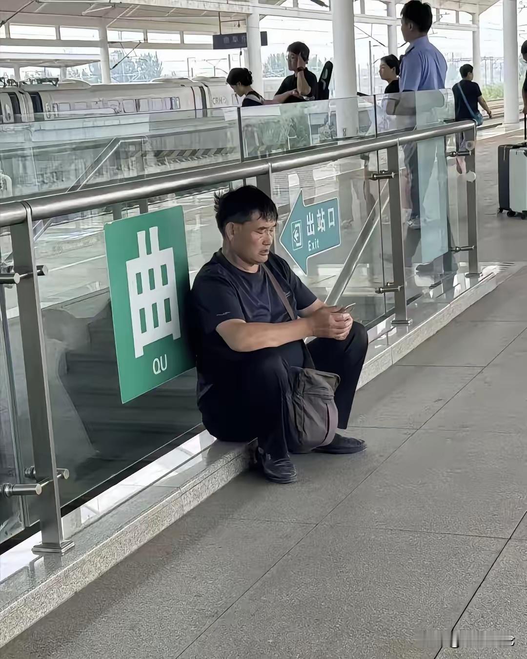 有人在高铁站偶遇大衣哥，在地上坐着看手机，和普通人一样，大衣哥富了以后也没有飘，