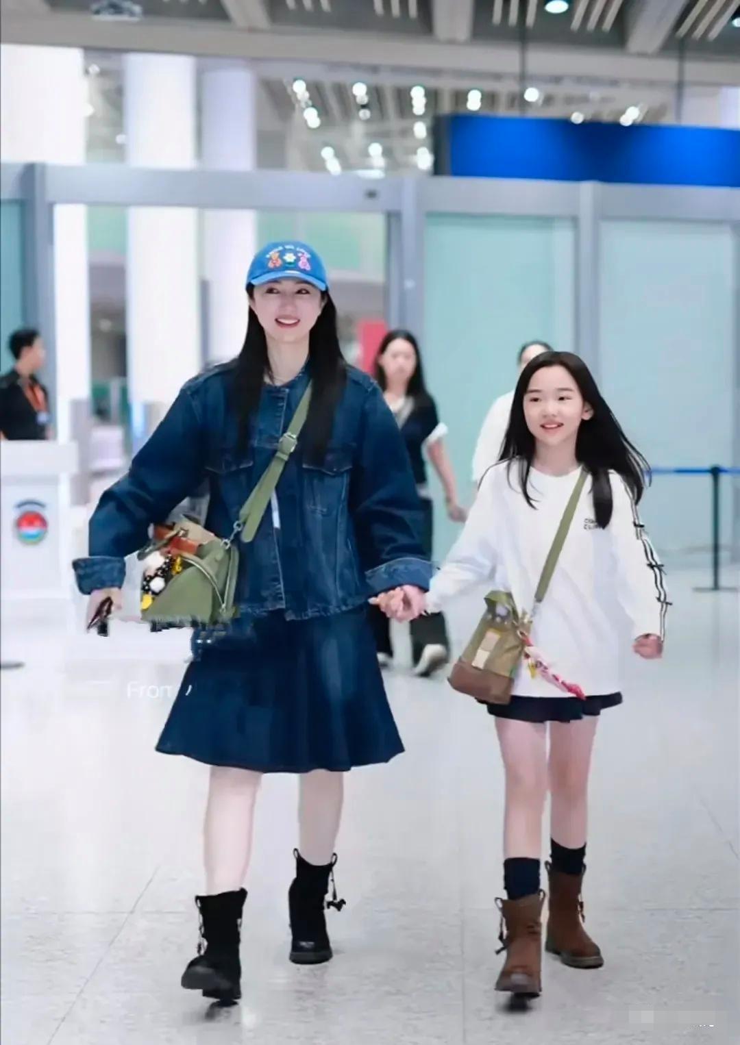 董璇现身北京机场，接小酒窝回来上学。母女二人手牵手向前行走，全程面带笑容，氛围轻