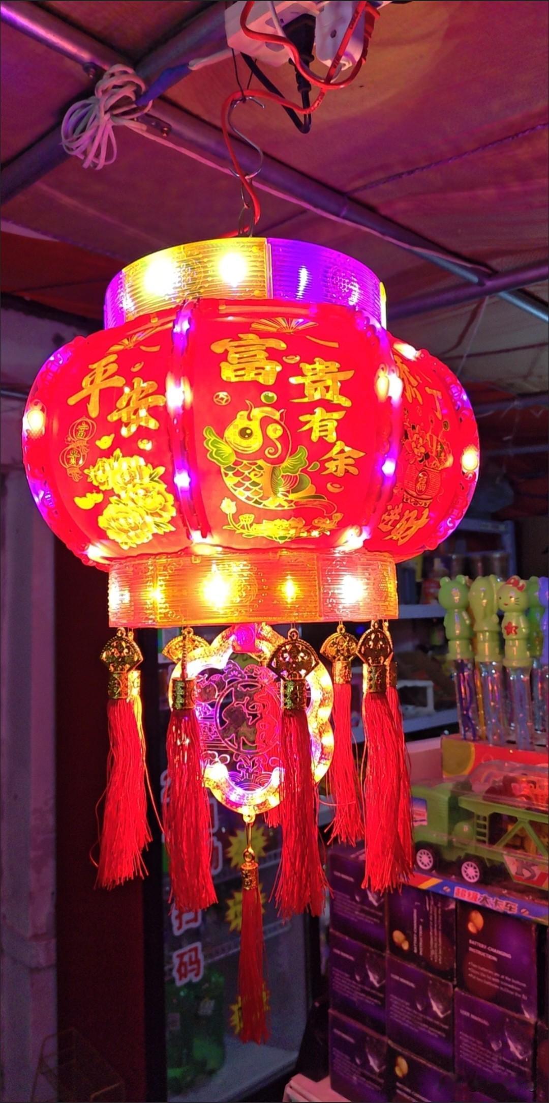 一、红灯笼挂起，年味悄然浓
指尖抚过朱红笼面，金线绣就的吉祥纹样在阳光下流转，这