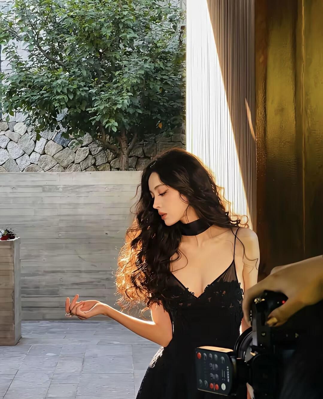 娜扎
卷发里藏着一朵黑玫瑰
像把夜晚折进鬓角
丝绒颈圈勒住半片呼吸
蕾丝裙裾，是