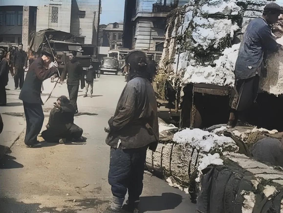 1946年，上海街头，一名巡警挥舞着警棍，正在殴打一个妇女，仔细看这个妇女瘫坐在
