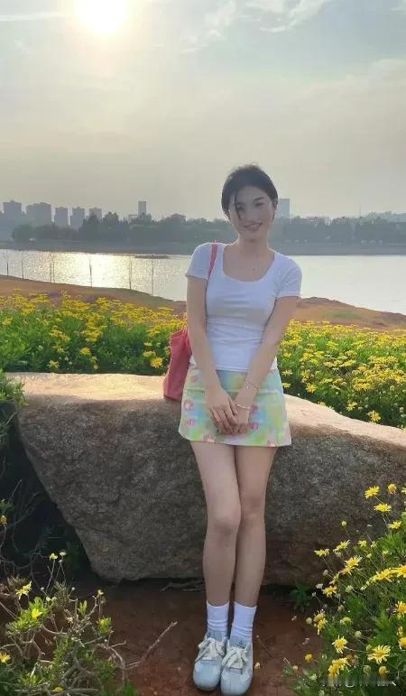 阳光明媚，她站在花丛中微笑。