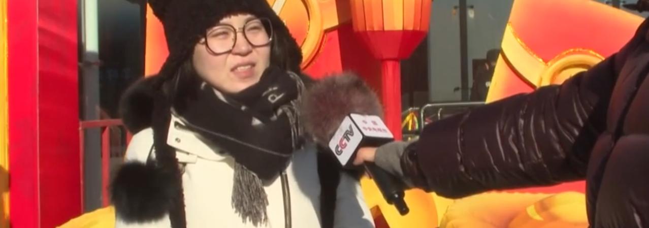 第一张图中，记者手持央视话筒对市民进行新年采访，市民身着厚实的冬装，背景是红黄相