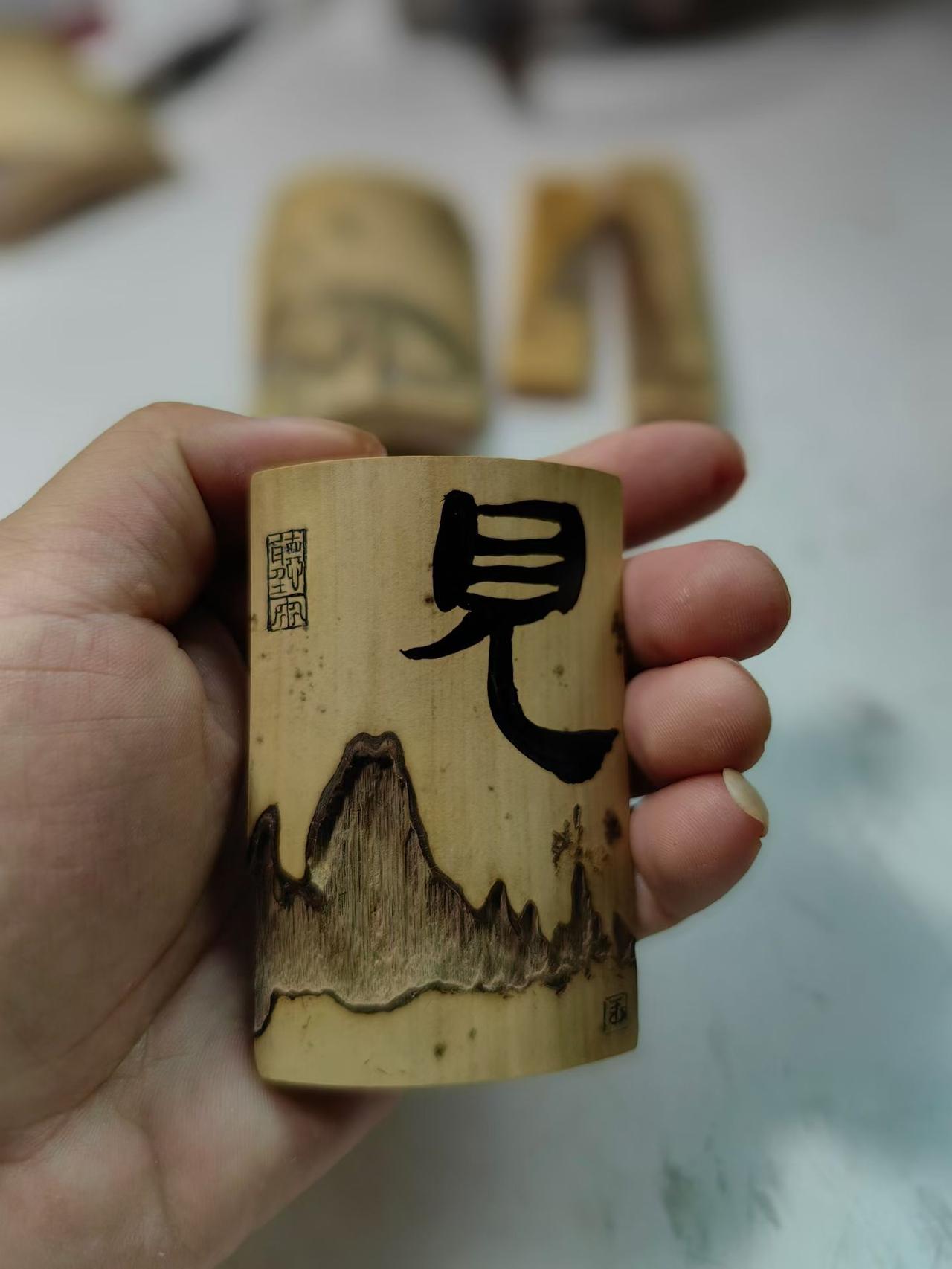这块竹料底部有虫蛀残缺，天然纹路刚好形似隶书的“山”字；左上方的破损处盖一方印章