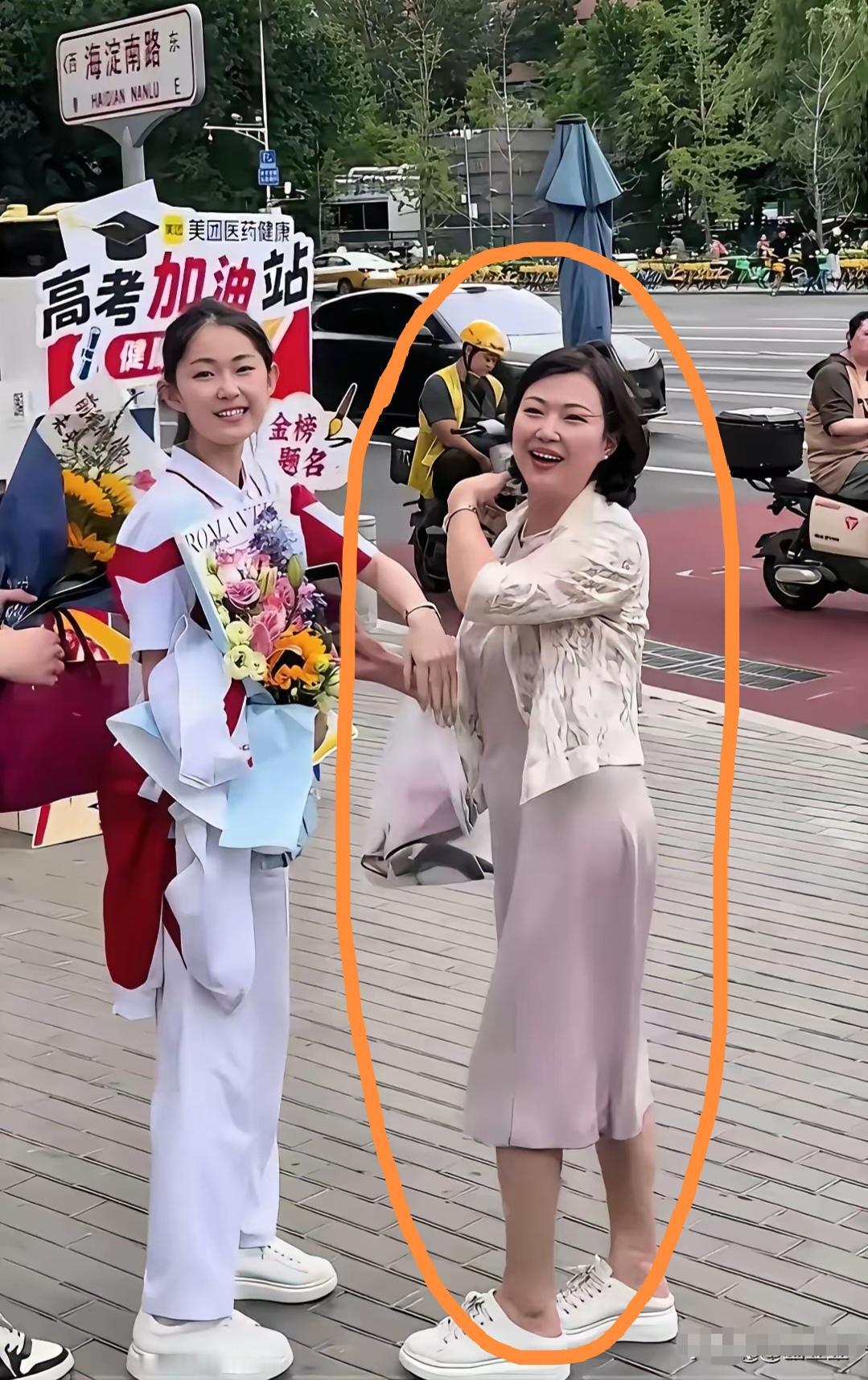 当女儿走出考场的那一刻，妈妈手捧天花兴奋的朝女儿跑去，母女俩喜悦之情溢于言表！仔