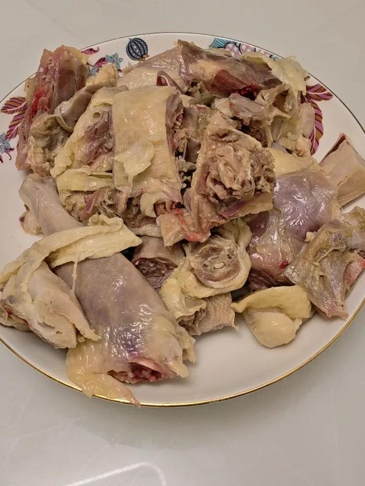 昨天拿出冰柜里的湖北荆门风干鸡，放在外面解冻。

今天拿刀剁成块。看了肉，像是生