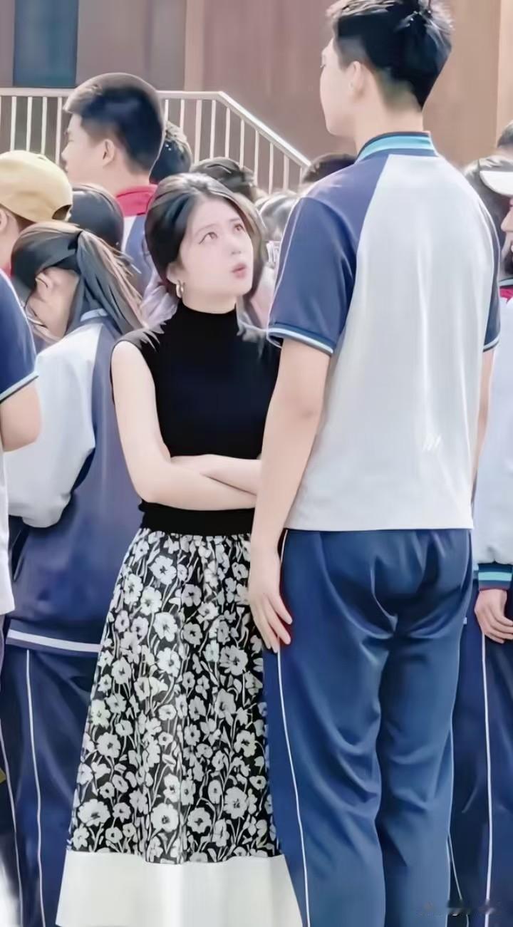 画面里身高一米九三的少年垂着头，被身前的妈妈仰头训斥，一脸生无可恋。周围是穿着同