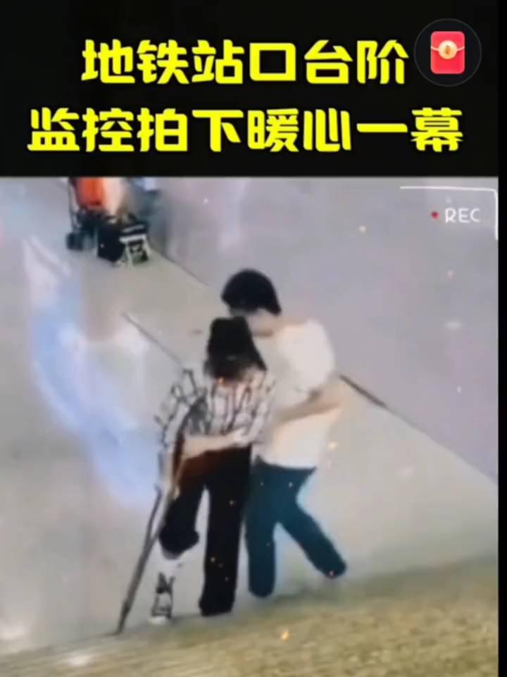 地铁站口台阶，监控拍下暖心一幕。