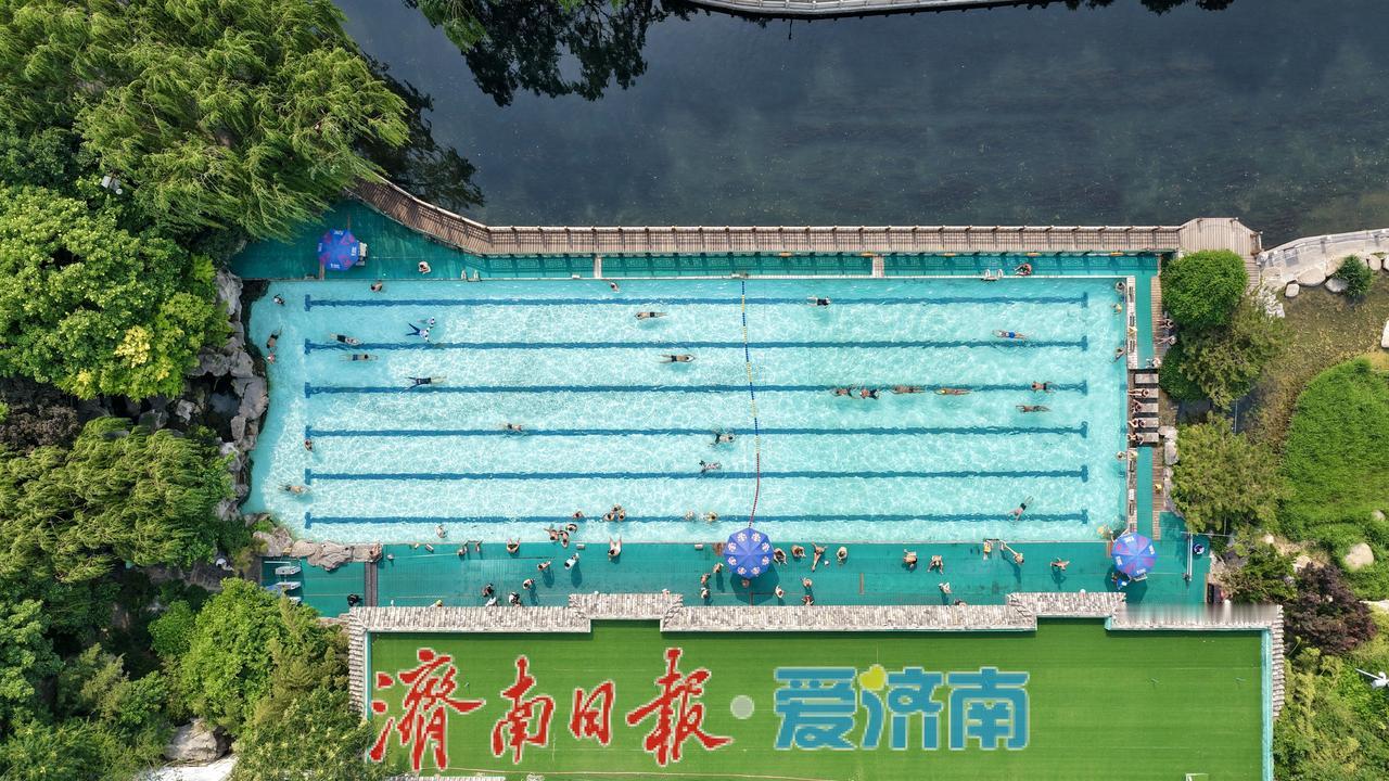 5月14日，济南泉水浴场迎来络绎不绝的人流。清澈见底的池水中，游泳的市民游客或畅