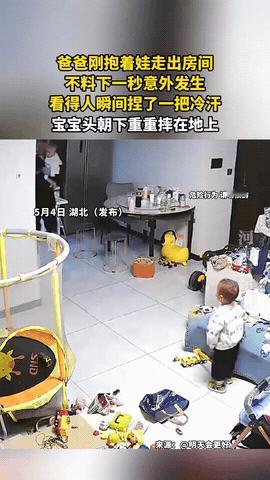 心不是一般的大！湖北，爸爸抱着自家小宝宝从房间里走出来，左手搂着娃，右手还在那儿