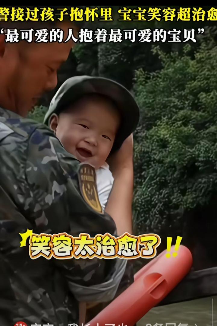 好温馨的一幕!虽然不是亲父子，但宝宝知道在武警叔叔的怀里最踏实!宝宝的笑容已然说