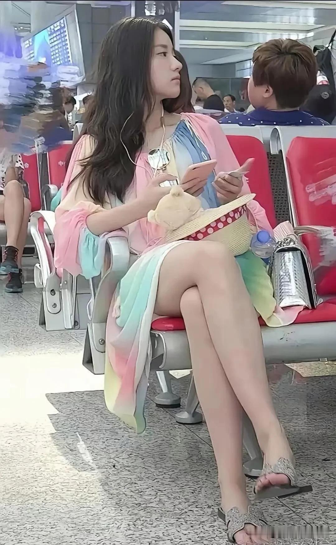 在高铁站，发现一位候车的女孩静静地看着手机，从那精致叠放的修长双腿可以看出她身材