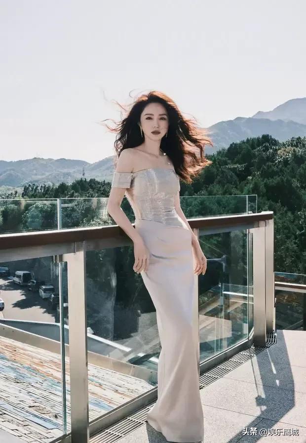 近日，董璇的一组时尚大片释出。图中，董璇穿着白色的露肩礼服，头发随风飞扬，倚在窗