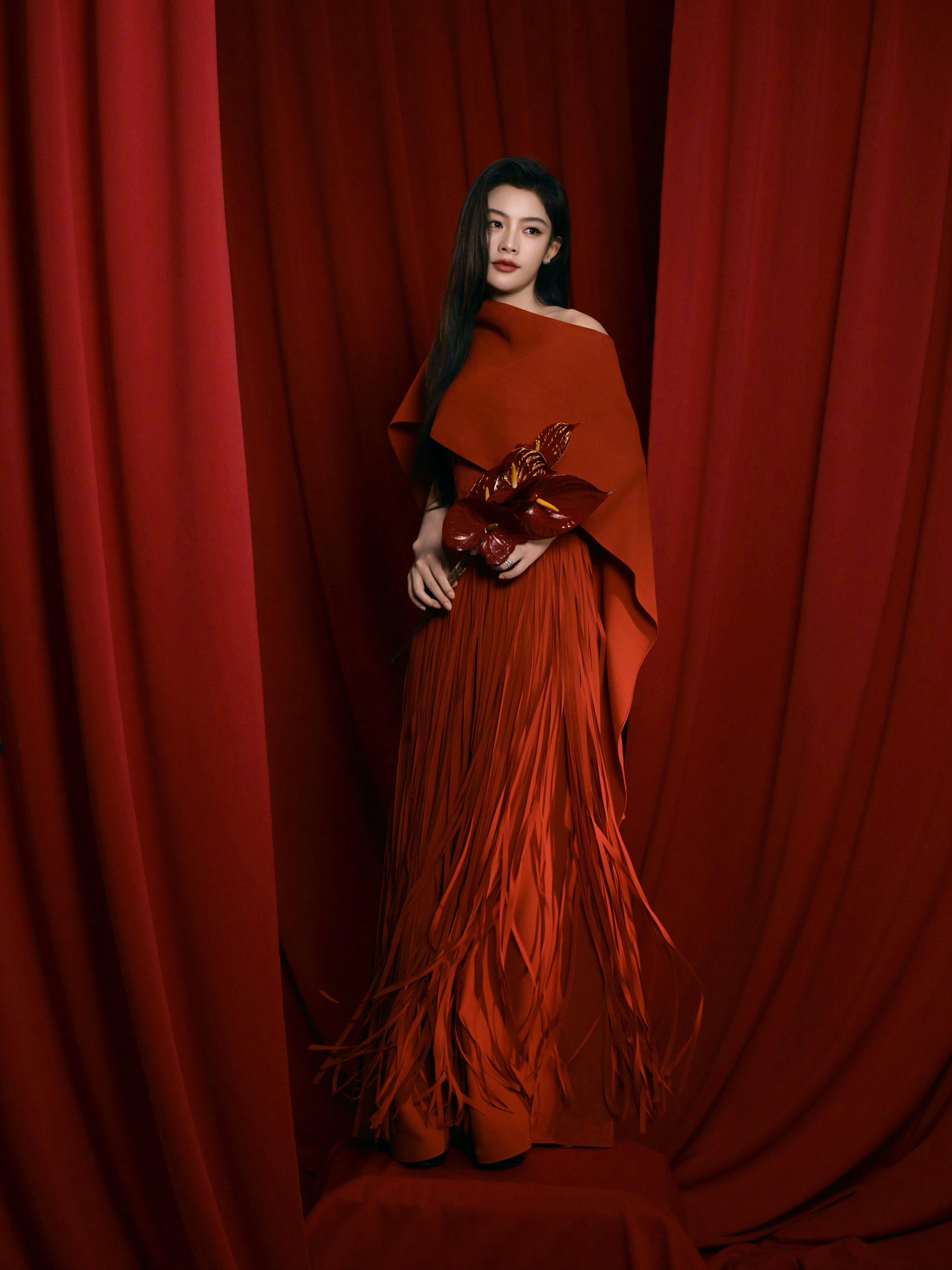 陈丽君今日参加 微博之夜的造型，以正红色为主调，结合不对称披肩设计与流苏裙摆，展