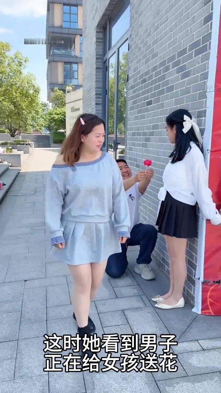 路过女子阻止男子给女孩送鲜花，这一幕真的太无奈了。
女孩正在走路时，这时她看到男