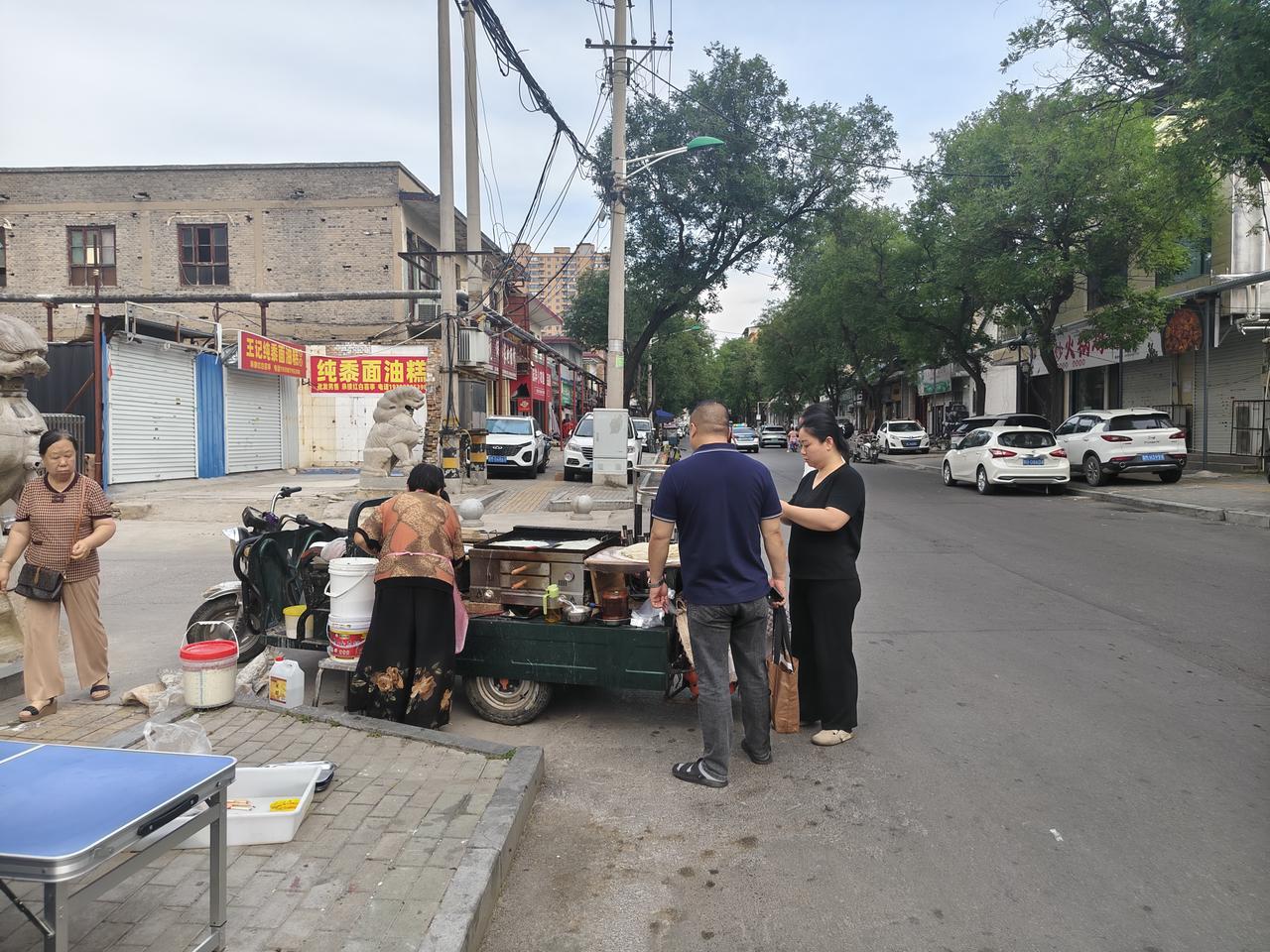 您瞧，在运城市盐湖西街，一位大婶正在一小区门口摊煎饼，一元一个。远远的，我就看到