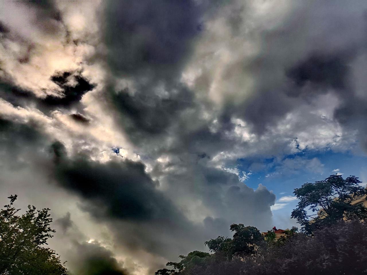 乌云翻涌漫过天际，几缕天光奋力穿透云层，一角蓝天显露，晨起的天空壮阔又充满张力。