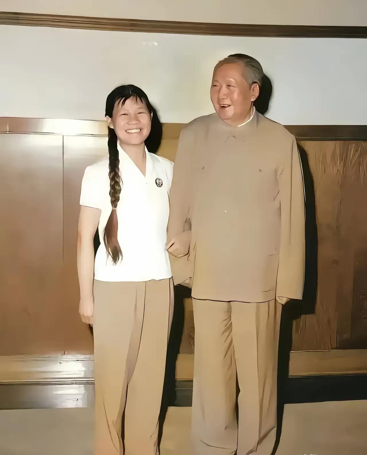 这张照片拍摄于1970年，一位年轻漂亮工作人员挽着他的胳膊，梳着垂至肩腰的粗粗两