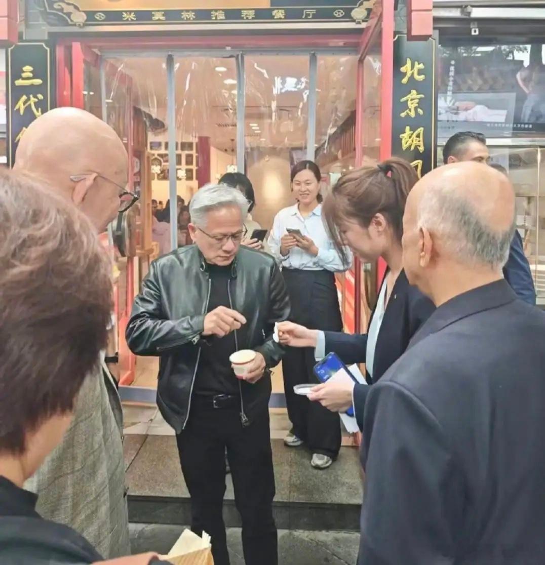 英伟达总裁黄仁勋现身北京南锣鼓巷，吃了他心心念念很久的炸酱面，他站在店门口，端着
