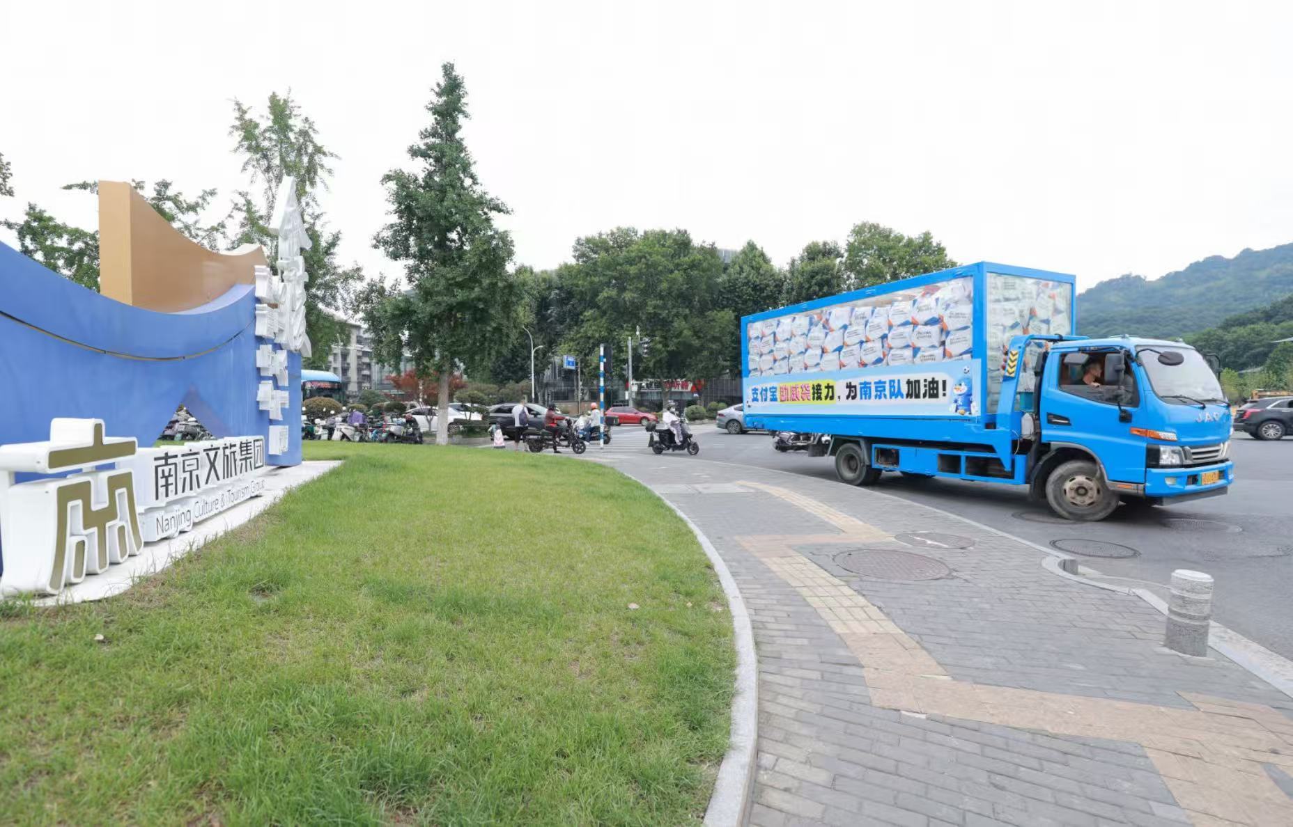 苏超助威袋坐着卡车来南京了 助威袋搭乘卡车亮相南京街头，满满一车惊喜派送不停，各