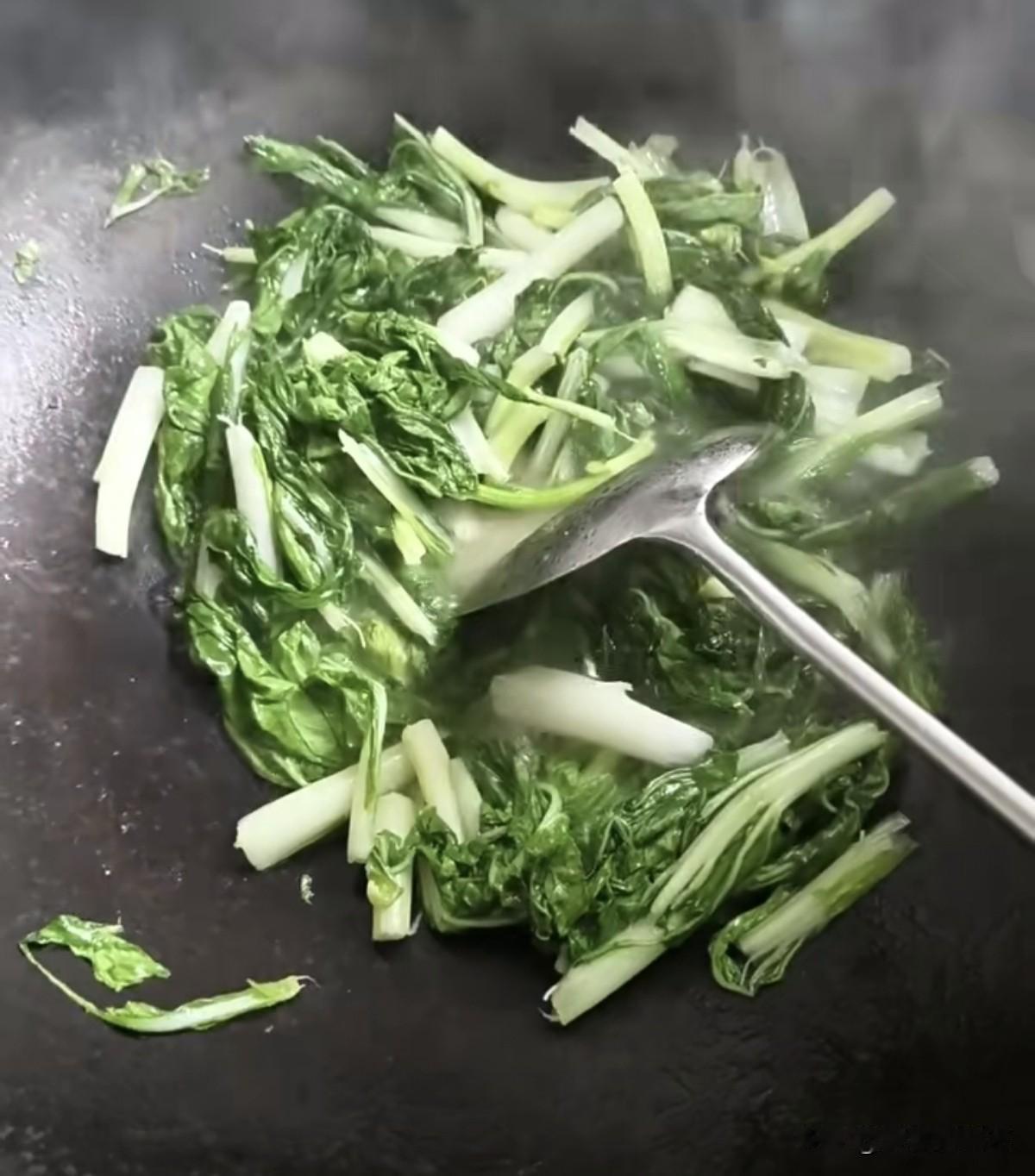秋日生活打卡季铁锅升腾起袅袅热气，鲜嫩的白菜在锅中翻炒。翠绿叶菜色泽鲜亮，简单清