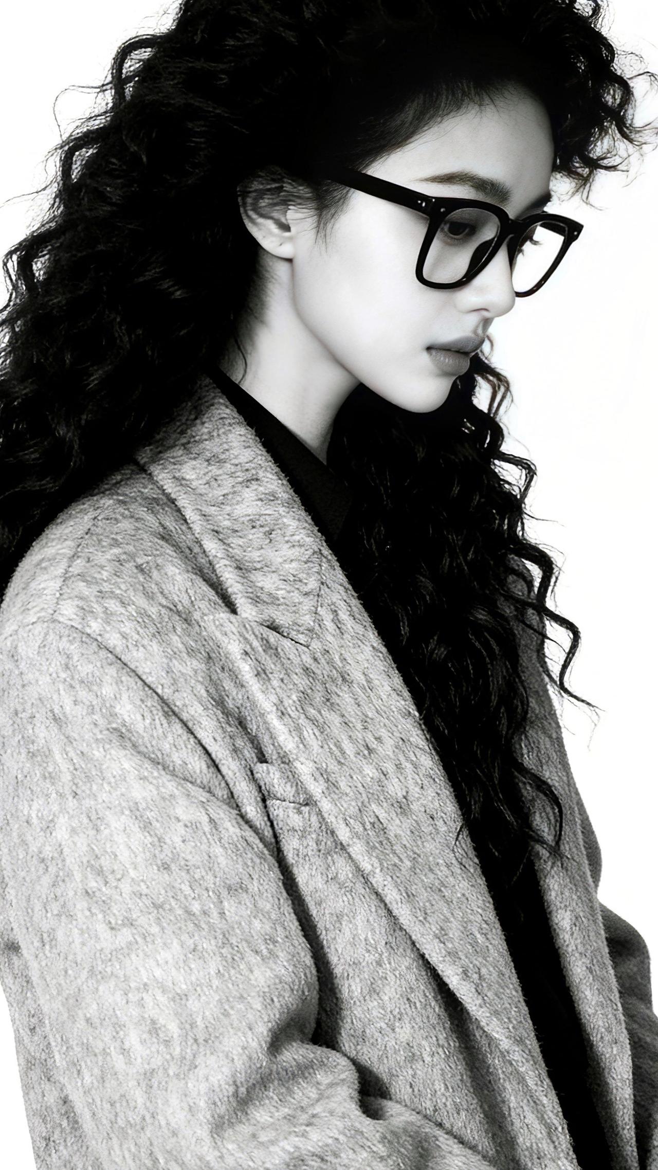 九帧同绘知性卷发仙。黑框眼镜添书卷气，卷发如瀑流光垂肩，灰呢外套衬玉骨。纯白背景