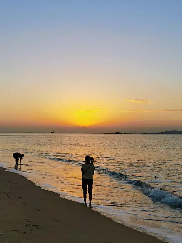 相册里最满意的照片，一张是在海边看日出的留影。那时天边刚泛鱼肚白，红日从海平面缓