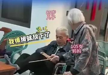 105岁的妈妈看到85岁的儿子翘二郎腿，伸手指着他"嗔怪"，那个85岁的老头不仅