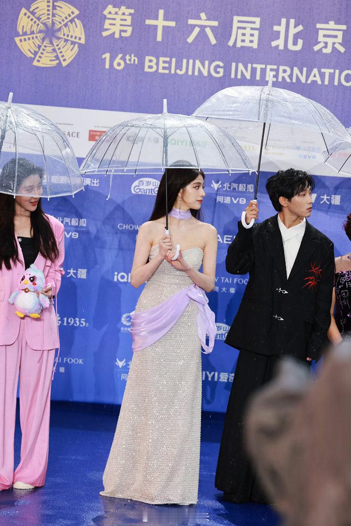 钟丽丽被雨淋了 别人撑伞她淋雨，不是故意搞特殊，是站中间真的没法撑。收伞之后雨水