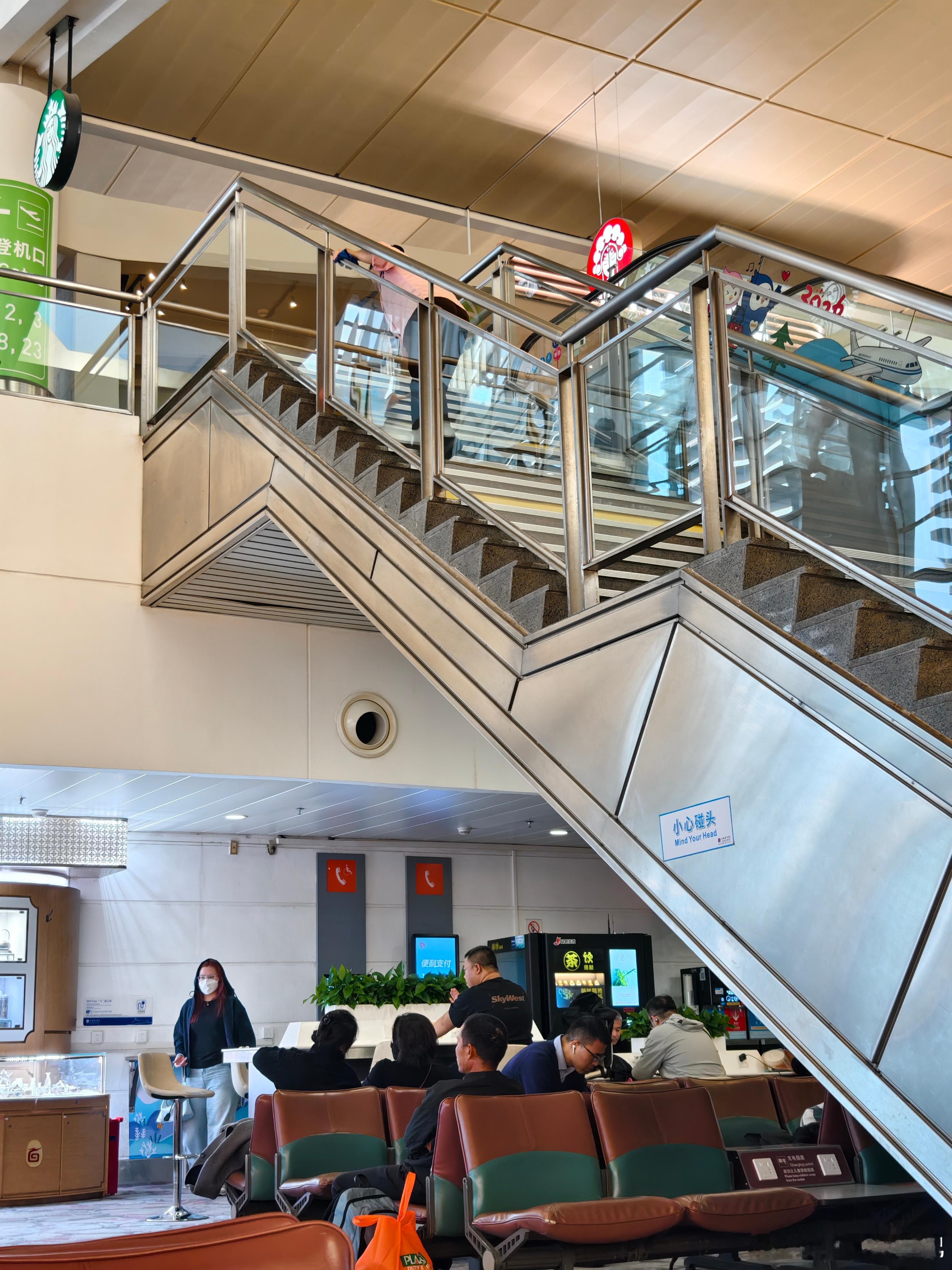 这大姐拿着鸡毛掸在楼梯上一层一层的扫栏杆下的灰尘挺辛苦，就是可怜了坐在下面的旅客